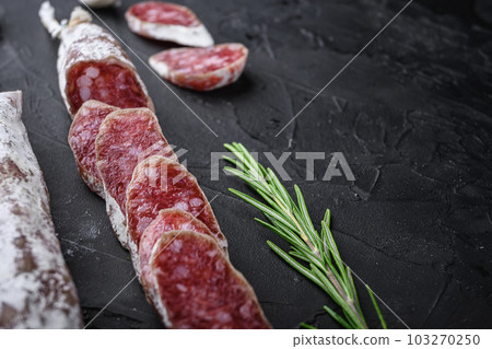 Dry cured fuet salami sausage slices  on balck background with copy space 103270250