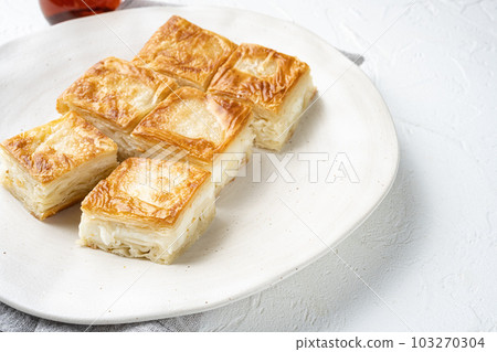 Turkish style meat and cheese stuffed filo dough borek, on white stone table background, with copy space for text 103270304