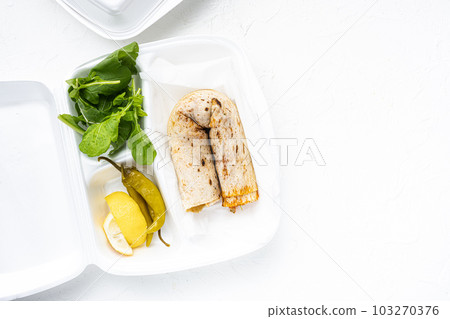 Turkish Style chicken roll Tavuk Durum tantuni, in plastic pack container delivery lunch box, on white stone table background, top view flat lay, with copy space for text Turkish Style chicken roll Tavuk Durum tantuni, in plastic pack container delivery lunch box, on white stone table background, top view flat lay, with copy space for text 103270376