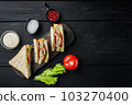 Club sandwich with meat, cheese, tomato, ham, on black wooden background, top view with copy space for text 103270400