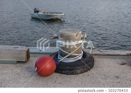 Photograph of white rope wrapped around a steel bollard with a mooring buoy on King Island Photograph of white rope wrapped around a steel bollard with a mooring buoy on King Island 103270433