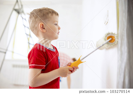Mother and child son paint the wall with paint using roller and brush Mother and child son paint the wall with paint using roller and brush 103270514