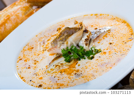 Tasty soup with white fish pollock and greens at white plate Tasty soup with white fish pollock and greens at white plate 103271113