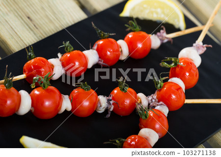 Skewers with mini calamari and tomatoes 103271138