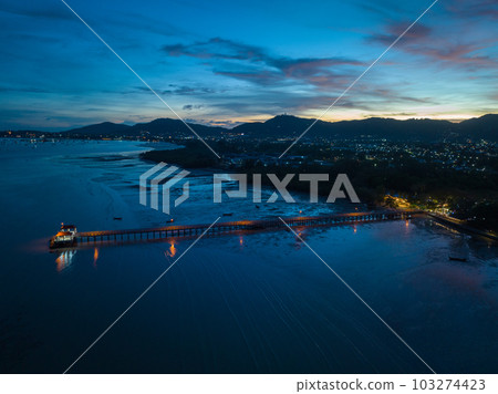 aerial photography cloud above Palai pier at beautiful sunset..Palai pier is next to Chalong pier..fishing boats parking on the beach..colorful cloud above the mountain range background.. 103274423