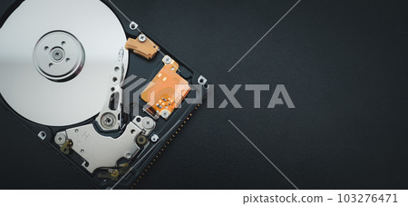An open hard disk disassembled HDD of a computer or laptop lies on a purple surface. Computer hardware and accessories. Hard disk storage. 103276471