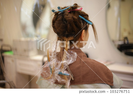 Woman holding her hair with a hair clip Woman holding her hair with a hair clip 103276751