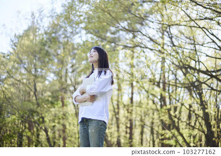 一位 30 多歲的日本女性喜歡在初夏的旅遊景點放鬆身心 103277162