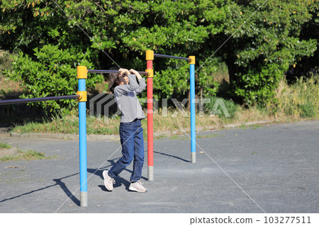 Elementary school girl playing horizontal bar (8 years old) 103277511