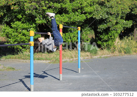Elementary school girl playing horizontal bar (8 years old) 103277512