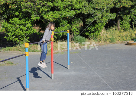 Elementary school girl playing horizontal bar (8 years old) 103277513