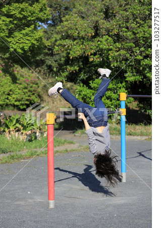 Elementary school girl playing horizontal bar (8 years old) Elementary school girl playing horizontal bar (8 years old) 103277517