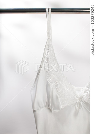 A white sleepwear are hanging on the clothesline A white sleepwear are hanging on the clothesline 103279243
