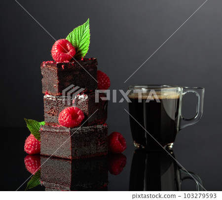 Chocolate cake with fresh raspberries and black coffee. 103279593