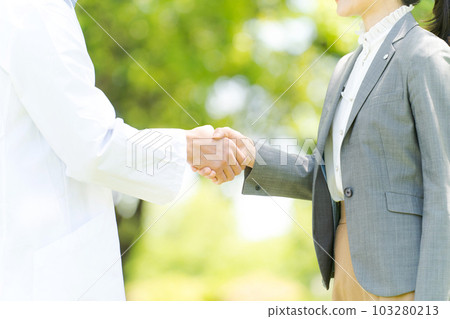 Photo of a female and male doctor shaking hands Photo of a female and male doctor shaking hands 103280213