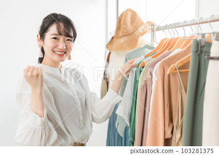 一家做膽量姿勢的商店,一名在服裝店工作的微笑銷售員,一名員工,一名亞裔女性在店員 一家做膽量姿勢的商店,一名在服裝店工作的微笑銷售員,一名員工,一名亞裔女性在店員 103281375