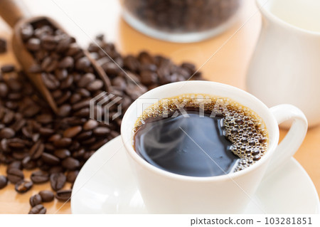Hot coffee and coffee beans on the table 103281851