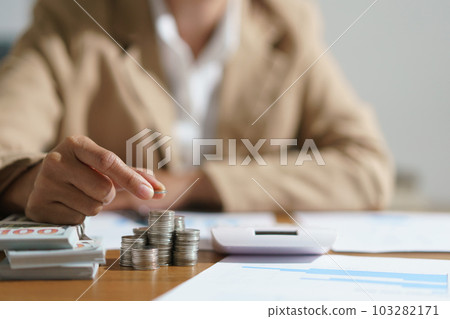 Businesswoman putting a coin on the pile of coins with saving money idea for investment business 103282171