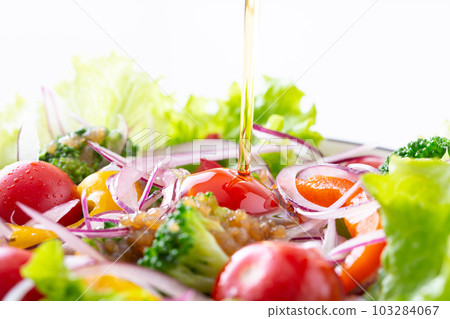 Apply olive oil to vegetable salad Apply olive oil to vegetable salad 103284067