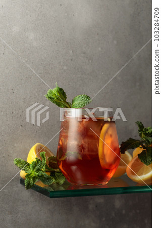 Iced tea with lemon and mint on the background of the grey concrete wall. 103284709