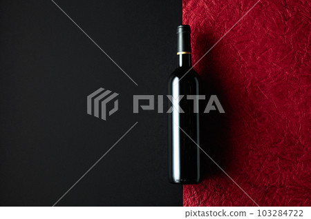 Bottle of red wine on a background of the old red crumpled paper. 103284722