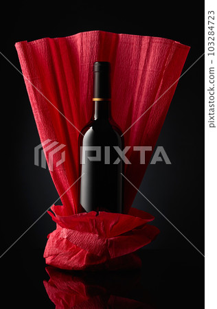 Bottle of red wine on a crumpled paper. 103284723