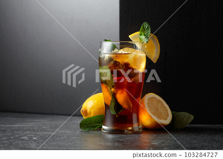 Iced tea or a summer refreshing drink with ice, mint, and lemon. Iced tea or a summer refreshing drink with ice, mint, and lemon. 103284727