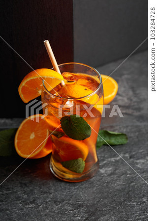 Iced tea or a summer refreshing drink with ice, mint, and orange. 103284728