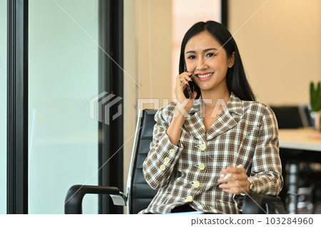 Friendly female financial consultant chatting with client, giving internet consultation to customer on mobile phone Friendly female financial consultant chatting with client, giving internet consultation to customer on mobile phone 103284960
