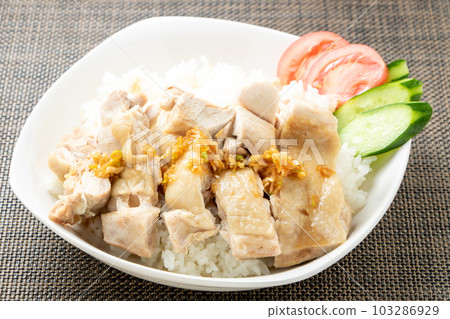 Singapore chicken rice (Hainanese chicken rice) style, chicken soup cooked rice topped with chicken. 103286929