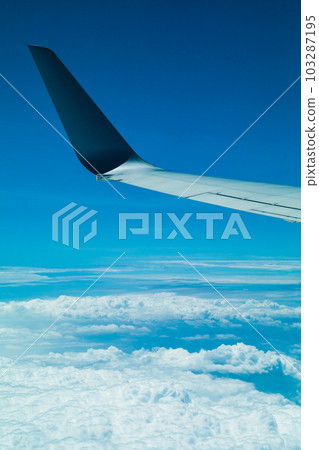 White clouds and blue sky, wing of a flying plane. White clouds and blue sky, wing of a flying plane. 103287195