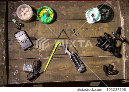 Multifunctional knife with scissors. Scissors and other tools for fishing. Tools on the box. View from above. Multifunctional knife with scissors. Scissors and other tools for fishing. Tools on the box. View from above. 103287598