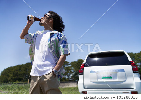 中年男子站在藍天下喝著飲料 103288313