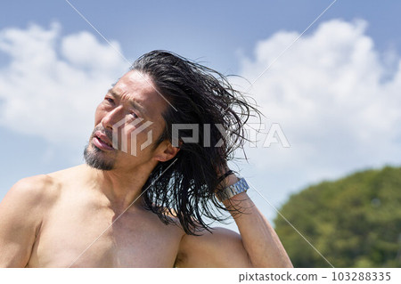 Middle senior man drying wet hair outdoors in the blue sky 103288335