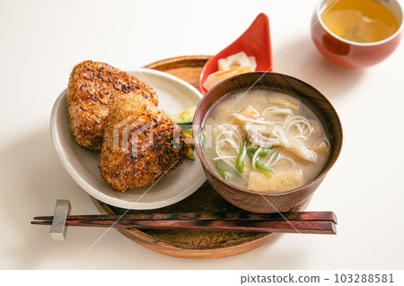A Japanese set of two grilled rice balls and Nyumen (miso soup with maitake mushrooms, green onions, fried tofu and somen noodles). 103288581