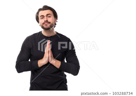 young handsome caucasian brunette man with beard in informal style praying 103288734