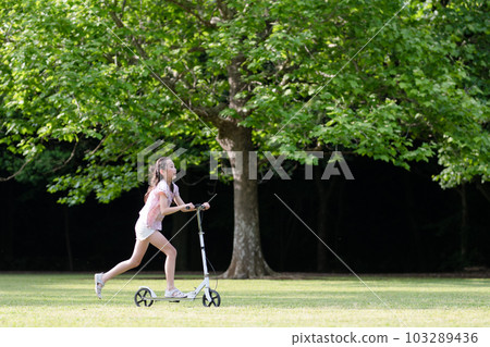 Girl playing with kick skater 103289436