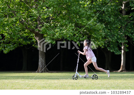 Girl playing with kick skater 103289437