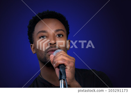 rock music singer holding microphone on blue background party karaoke performance rock music singer holding microphone on blue background party karaoke performance 103291173