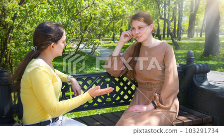 Two girls talking in the park 103291734