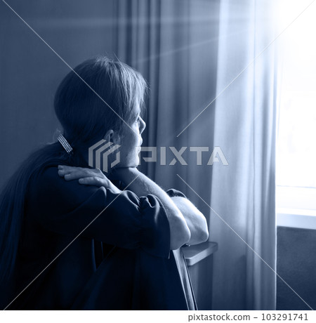 Sad girl sitting by the window Sad girl sitting by the window 103291741