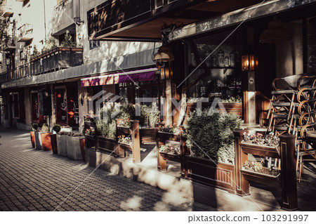 Street view with beautiful buildings and cafe terrace during the morning light concept photo. Street view with beautiful buildings and cafe terrace during the morning light concept photo. 103291997