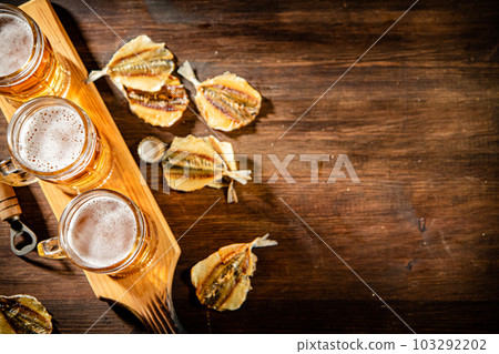 Glasses of beer with dried fish. 103292202