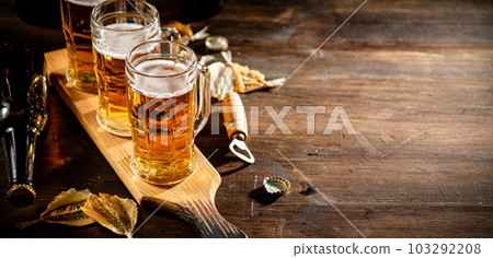 Glasses of beer with dried fish. 103292208