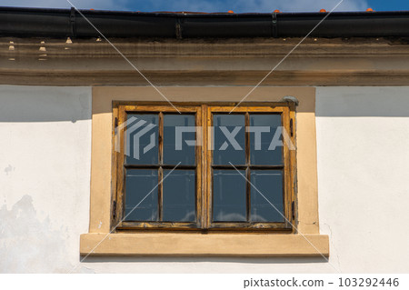 A windows under the roof on the facade of a historic building A windows under the roof on the facade of a historic building 103292446