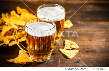 Fresh beer with corn chips. 103294006