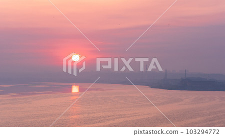 dawn landscape, morning sunrise over the river with cityscape on the shore 103294772