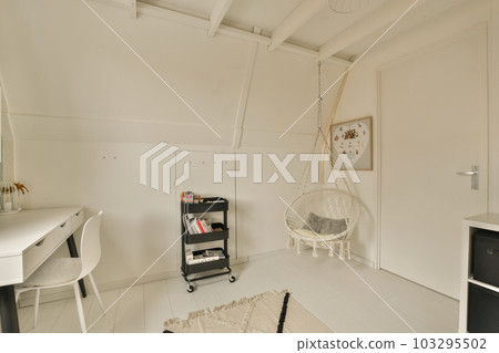 a room with white walls and wood flooring, there is a hanging chair in the corner of the room a room with white walls and wood flooring, there is a hanging chair in the corner of the room 103295502