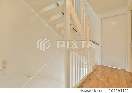 an empty room with wood flooring and white railings on the staircase leading up to the second floor in this house an empty room with wood flooring and white railings on the staircase leading up to the second floor in this house 103295503