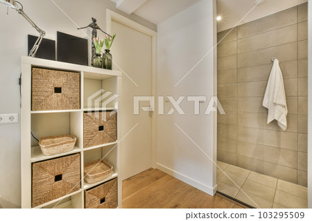 a bathroom with some baskets on the shelves and a towel hanging from the shower stall in the wall is tiled a bathroom with some baskets on the shelves and a towel hanging from the shower stall in the wall is tiled 103295509